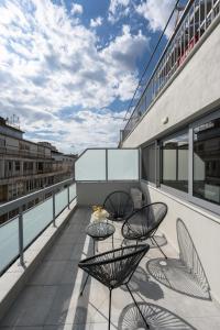Un balcón con 2 mesas y sillas en un edificio en #Luxlikehome Lux Locals 2 en Tesalónica