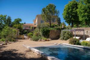 a backyard with a swimming pool and a house at Villa Bam Bam in Apt