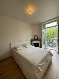 a bedroom with a bed and a large window at Appartement moderne Place du Marché in Aix-les-Bains