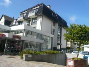 a large white building with a store in front of it at Fischer in Westerland