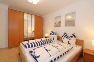 a bedroom with two beds with blue and white pillows at Fischer in Westerland