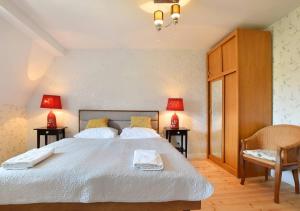 a bedroom with a large white bed with two lamps at Apartamenty Willa & sauny in Kudowa-Zdrój +22 photos