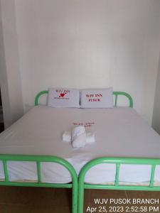 1 cama verde y blanca con 2 almohadas en WJV INN PUSOK en Pajo