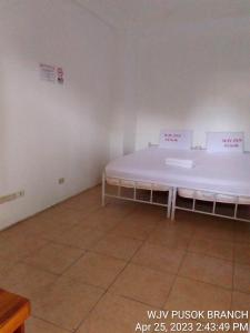 a bed in a room with writing on the wall at WJV INN PUSOK in Pajo