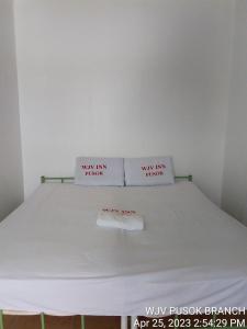 a bed with two white pillows on top of it at WJV INN PUSOK in Pajo +6 photos