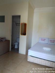 1 dormitorio con 1 cama y baño con aseo en WJV INN PUSOK en Pajo