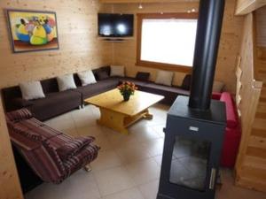 a living room with a couch and a wood stove at Chalet Bellevue in Les Orres