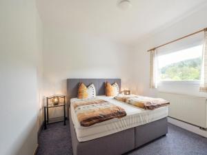 a bedroom with a large bed and a window at Captivating big holiday home in the Eifel National Park with garden and terrace in Schleiden