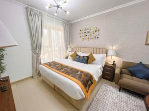a bedroom with a large bed and a chair at Cosmos Living Luxurious Studio Near Metro in Dubai