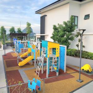 a playground with colorful play equipment in front of a building at Lost World Of Tambun Coco Guest House in Ipoh