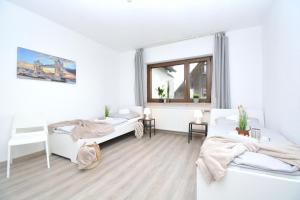 Habitación blanca con 2 camas y ventana en NUE10-FW Apartment in Lauf a.d. Pegnitz en Lauf an der Pegnitz