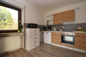una cocina con armarios de madera y una gran ventana en NUE10-FW Apartment in Lauf a.d. Pegnitz en Lauf an der Pegnitz