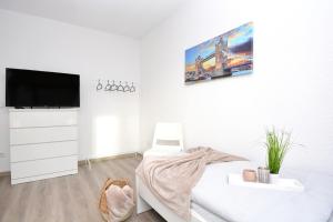 a white room with a bed and a tv on a wall at NUE10-FW Apartment in Lauf a.d. Pegnitz in Lauf an der Pegnitz
