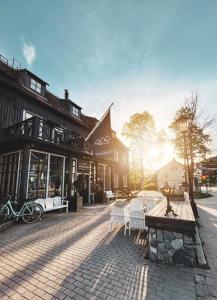 a cobblestone street with white benches in front of a building at Hotel Åregården in Åre