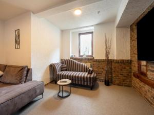 a living room with a couch and a tv at Eifel Nationalpark Grand Lodge in Schleiden +21 photos