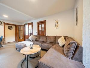 a living room with a couch and a table at Eifel Nationalpark Grand Lodge in Schleiden