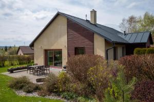 dom ze stołem i krzesłami przed nim w obiekcie FAMILY HOUSE Tisá w mieście Tisá