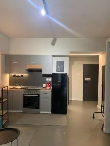 a kitchen with a black refrigerator and a stove at E2G URBAN STAY with Balcony in Thessaloniki