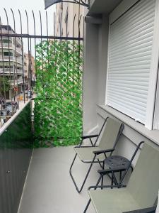 two chairs on a balcony with a green plant at E2G URBAN STAY with Balcony in Thessaloniki