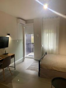 a bedroom with a bed and a desk and a television at E2G URBAN STAY with Balcony in Thessaloniki