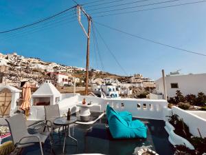 een balkon met stoelen en tafels en uitzicht op de stad bij aletrivillas in Éxo Goniá