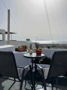 a table and chairs on a patio with a view of the ocean at aletrivillas in Éxo Goniá