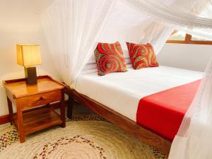 Un dormitorio con una cama y una mesa con una lámpara. en Heart of Africa Lodge, en Arusha 85 fotos más