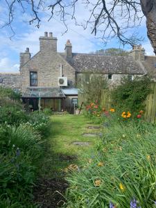 una casa antigua con un jardín delante de ella en Cobblers Cottage, en St Margaret's Hope