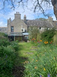 an old house with a garden in front of it at Cobblers Cottage in St Margaret's Hope