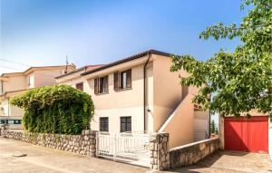 a house with a red garage in front of it at Nice Apartment In Dramalj With House Sea View in Dramalj