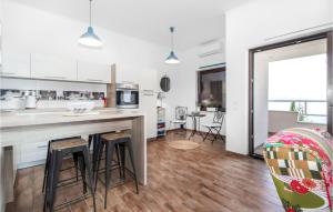 a kitchen with a counter and stools in a room at Nice Apartment In Dramalj With House Sea View in Dramalj