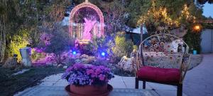 um jardim decorado com luzes e flores e uma cadeira em Refugio madera estilo árabe con estatuas, estanques y un pequeño zoo em Albacete