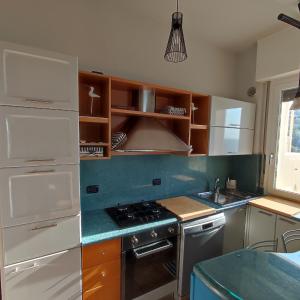 eine Küche mit weißen Geräten und Holzschränken in der Unterkunft Tramonto in Baia in Pesaro