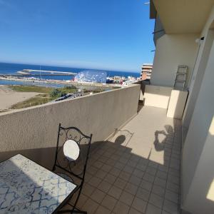 a balcony with a bench and a view of the beach at Tramonto in Baia in Pesaro