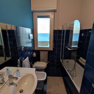 ein Badezimmer mit einem Waschbecken, einem WC und einer Badewanne in der Unterkunft Tramonto in Baia in Pesaro