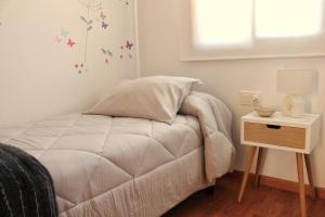 1 dormitorio con 1 cama y mesita de noche con lámpara en La Caseta de Beli en La Galera