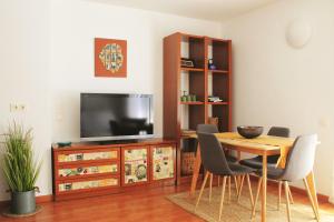 a dining room with a table and a television at La Caseta de Beli in La Galera
