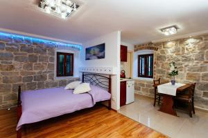 - une chambre avec un lit et un mur en pierre dans l'établissement House Sandra, à Split