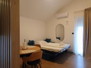 a room with two beds and a table and a mirror at Apartments Johnny in Podstrana