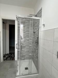 um chuveiro numa casa de banho com uma porta de vidro em Casa Girasole em Bardolino