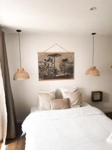 a bedroom with a white bed with two pendant lights at STUDIOS Neufs - COEUR de Barcelonnette - Parking privé in Barcelonnette