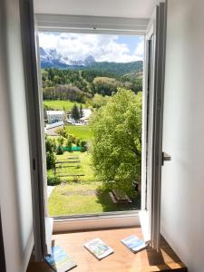 a window with a view of the mountains from a house at STUDIOS Neufs - COEUR de Barcelonnette - Parking privé in Barcelonnette