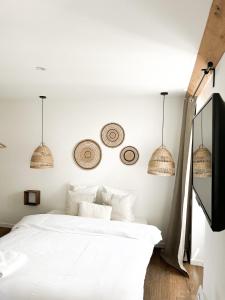 a bedroom with a white bed and two pendant lights at STUDIOS Neufs - COEUR de Barcelonnette - Parking privé in Barcelonnette