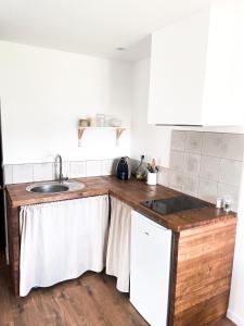 a kitchen with white cabinets and a sink at STUDIOS Neufs - COEUR de Barcelonnette - Parking privé in Barcelonnette