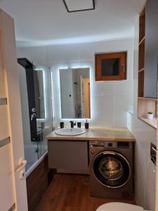 a bathroom with a washing machine and a sink at Peaceful&Central apartment with garden in Târgu-Mureş