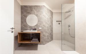 bagno con lavandino e specchio di Residence Hofgarten a Caldaro