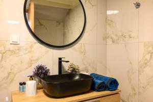 een badkamer met een zwarte wastafel en een spiegel bij Nicol studio for two center of Agios Nikolaos in Agios Nikolaos