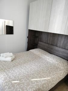 カモーリにあるCamogli Golfo Paradiso la casa del Comandanteのベッドルーム1室(大型ベッド1台、木製ヘッドボード付)
