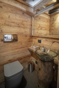 a wooden bathroom with a toilet and a sink at Appartamento NeveSole in San Vito di Cadore