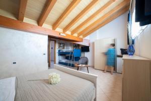 a bedroom with a bed and a woman in a room at Casa Merano Residence & Restaurant Bibione Centro in Bibione